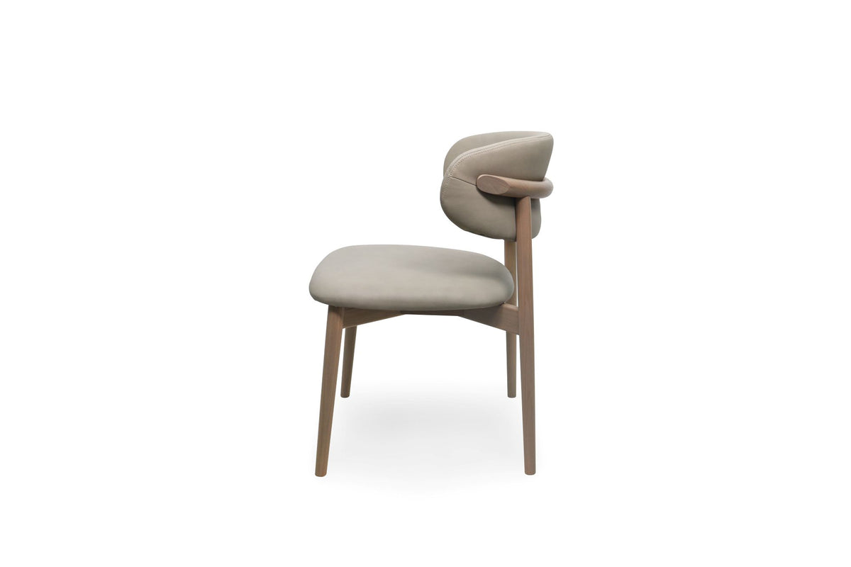 A modern dining chair with a light stone upholstered seat and curved backrest, supported by a light brown wooden frame, shown against a plain white background.