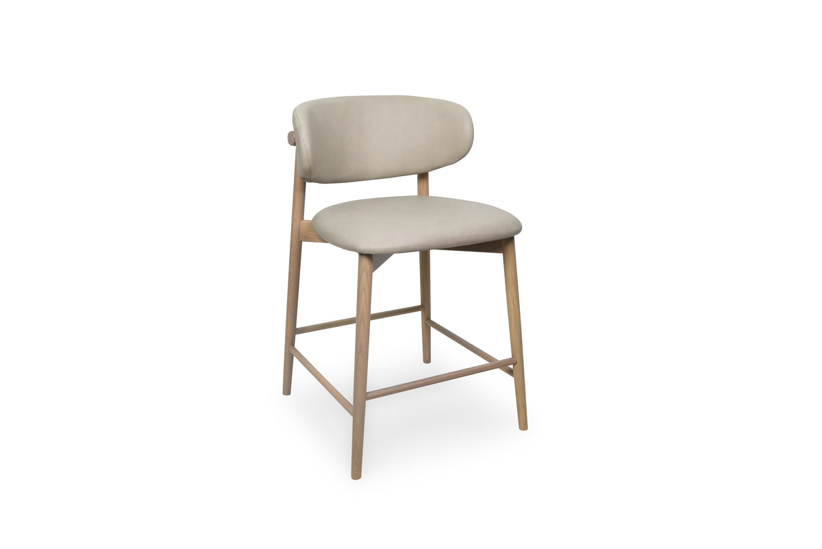 A modern bar stool with a light beige upholstered seat and curved backrest, supported by four tapered natural wood legs and a square metal frame.