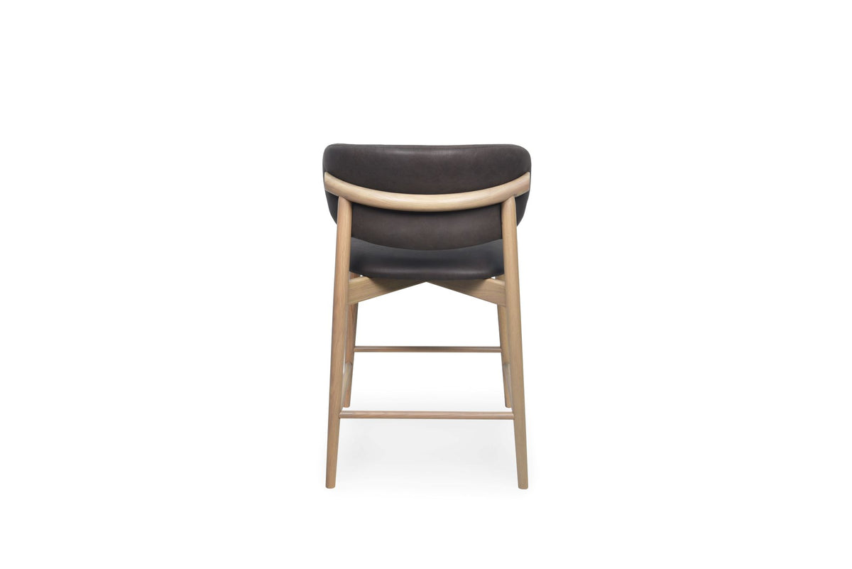 A modern bar stool with a dark chocolate upholstered seat and backrest, supported by a light natural wood frame and legs, shown from the front on a white background.