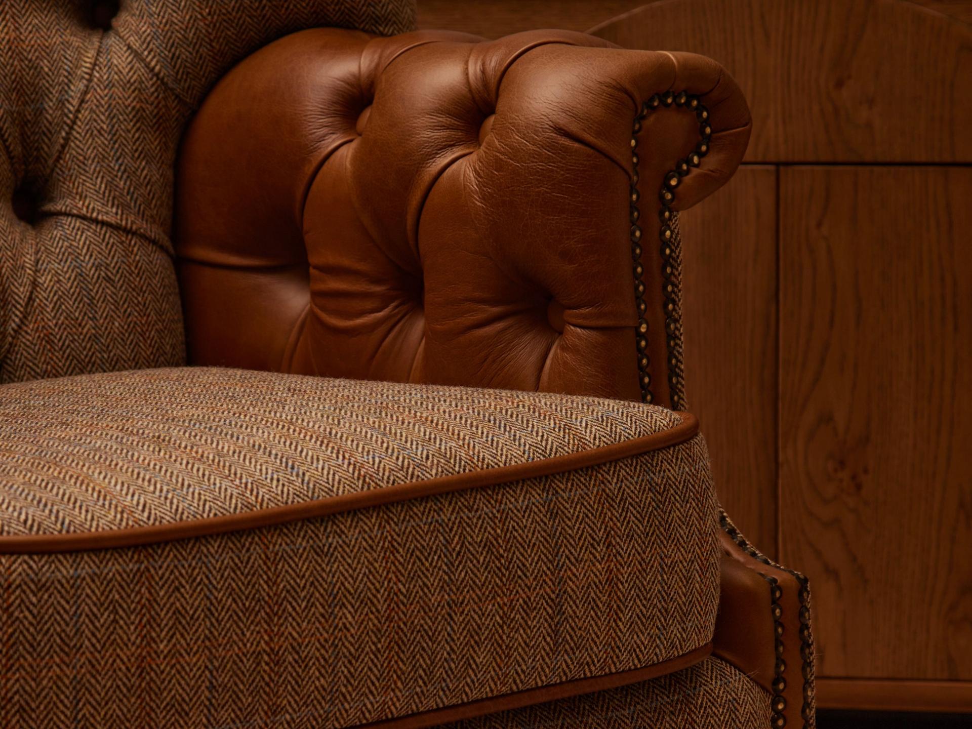 Close up of armchair with fabric seat and leather arms