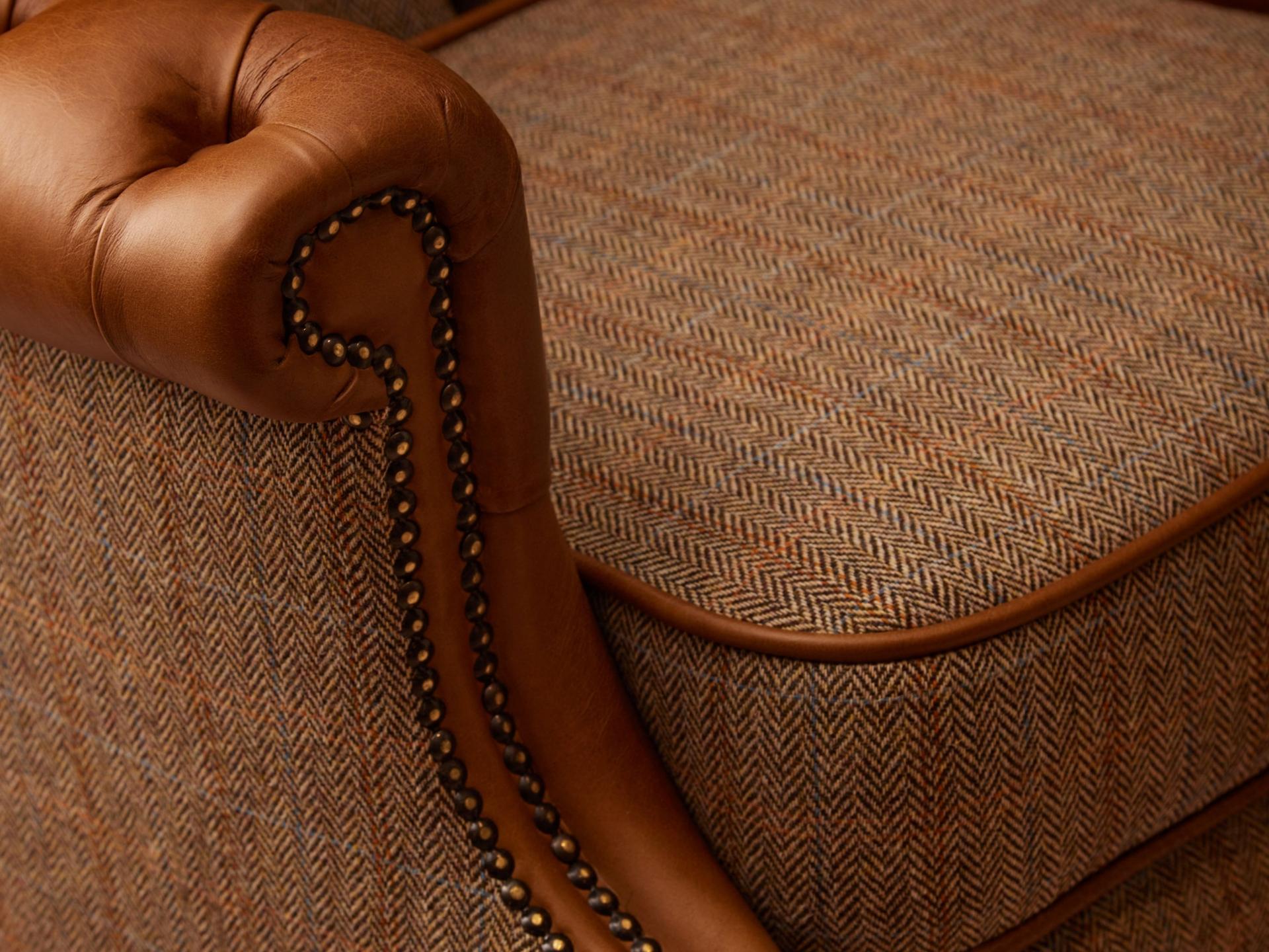 Close up of armchair with fabric seat and leather arms