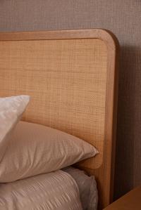 Mediterranean-inspired Felton Bed Frame headboard detail, handwoven natural rattan framed by American oak.