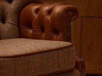 Close up of armchair with fabric seat and leather arms