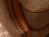 Close up of armchair with fabric seat and leather arms