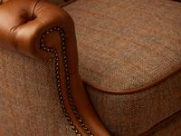Close up of armchair with fabric seat and leather arms