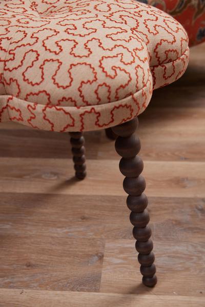Close-up of the fully upholstered Blossom Footstool in Wiggle Ginger fabric with hand-polished solid beech legs.