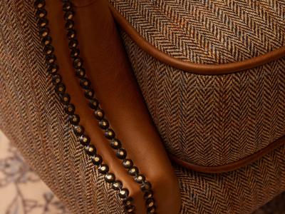 Close up of armchair with fabric seat and leather arms