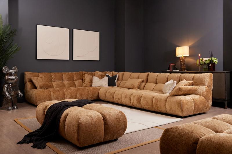 Gracelyn modular corner sofa in Shaun Old Gold fabric with matching ottoman, plush tufted cushions, styled in a modern living room set.