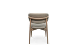 A modern upholstered dining chair with a curved backrest, upholstered in a light tone fabric, supported by a light oak wood frame, shown from the front on a white background.