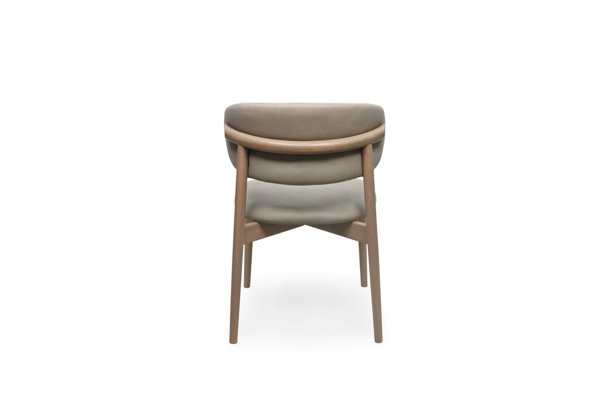 A modern upholstered dining chair with a curved backrest, upholstered in a light tone fabric, supported by a light oak wood frame, shown from the front on a white background.