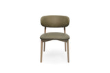 A modern dining chair with a rounded, cushioned backrest and seat upholstered in a muted olive green fabric, supported by light natural wood legs, shown against a plain white background.