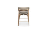 A modern high-back bar stool with a curved upholstered backrest and seat in a light taupe fabric, supported by a light natural wood frame, shown from the front on a white background.