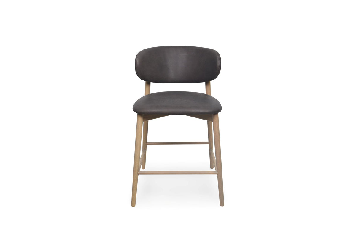 A modern counter stool with a dark chocolate upholstered seat and curved backrest, supported by four light natural wood legs with cross-bracing, shown against a plain white background.
