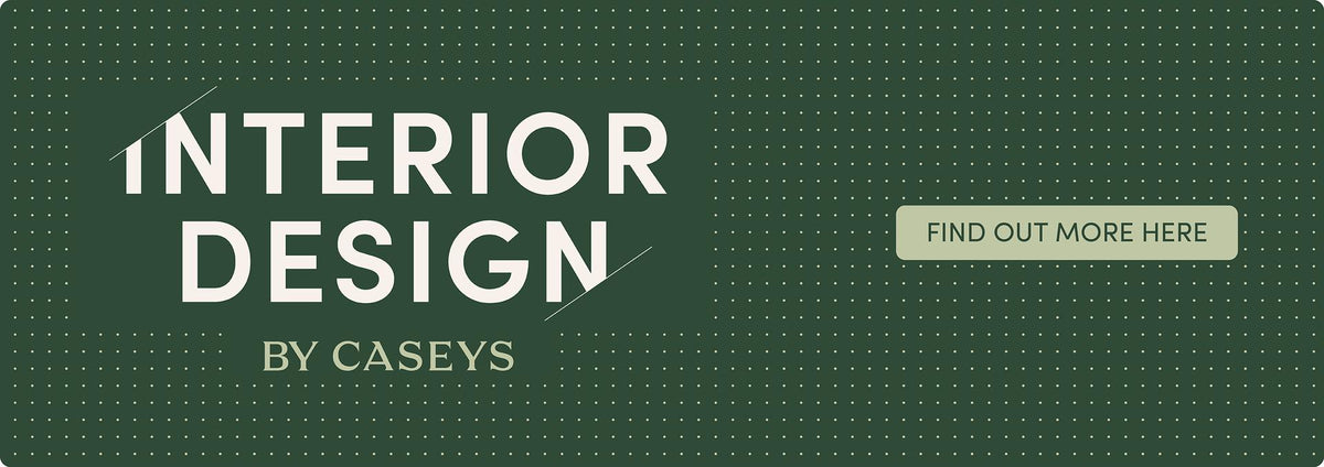 A dark green graphic banner with a dotted grid pattern, featuring the text 'INTERIOR DESIGN BY CASEYS' in white and a light beige button that reads 'FIND OUT MORE HERE'.